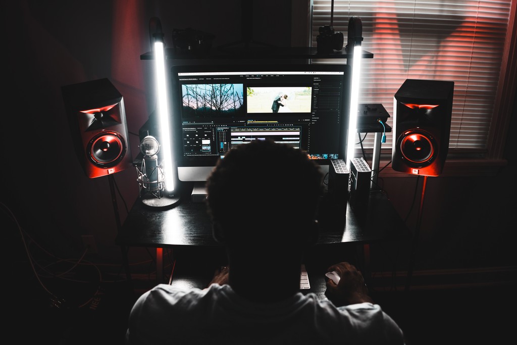 An editor grading footage in a darkened suite